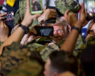 President Trump poses for photos with U.S. sailors and Marines during a visit aboard the amphibious assault ship USS Wasp (LHD 1) in 2019. 