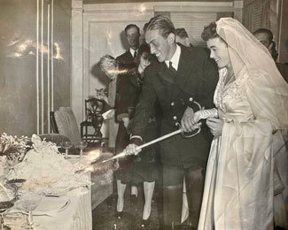 Sally Carton’s father in his naval uniform cutting the cake at their wedding. Photo courtesy of the author.