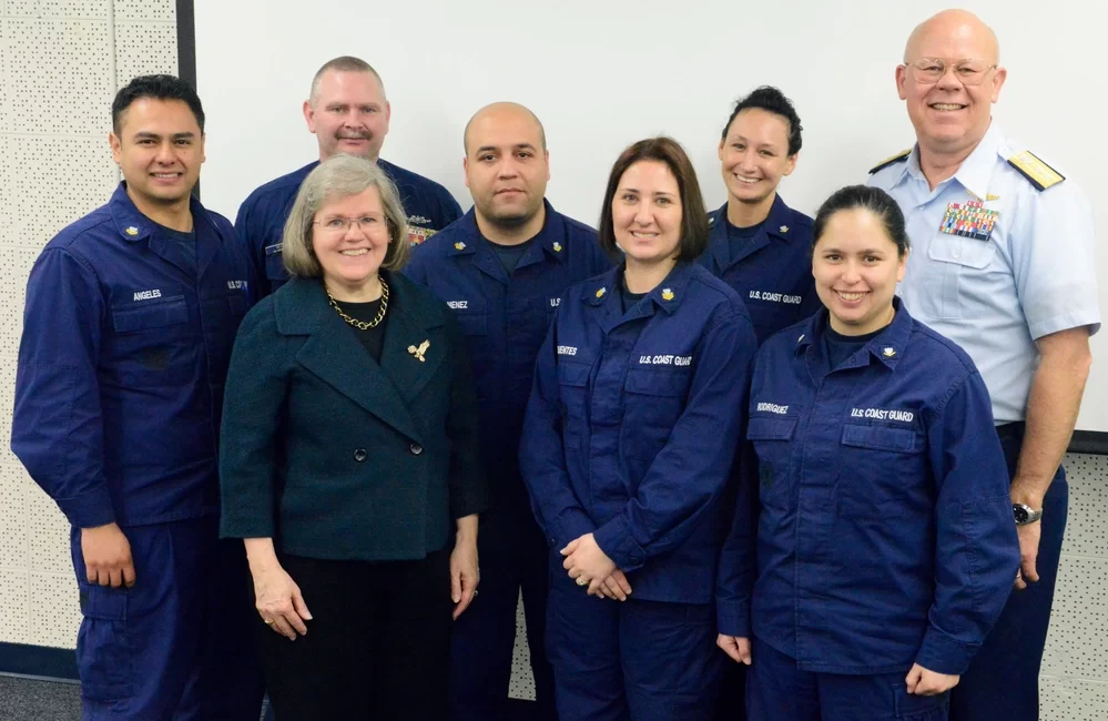 Holly Petraeus, the then-assistant director of the Consumer Financial Protection Bureau’s Office of Servicemember Affairs (front left), stands with Coast Guard personnel in 2015 after presenting steps taken by her office to improve financial options and safeguards available to military personnel and their families. Photo by Petty Officer 3rd Class Amanda Norcross, courtesy of the U.S. Coast Guard.