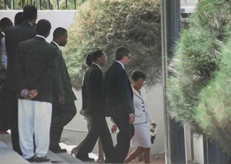 Former President Jean-Bertrand Aristide, third from the right, leaves the Palais Legislatif. Photo courtesy of the author.