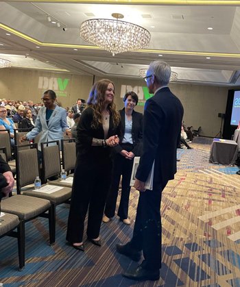 Jennifer Alvarado shakes hands with VA Secretary Denis McDonough at a Disabled American Veterans conference.