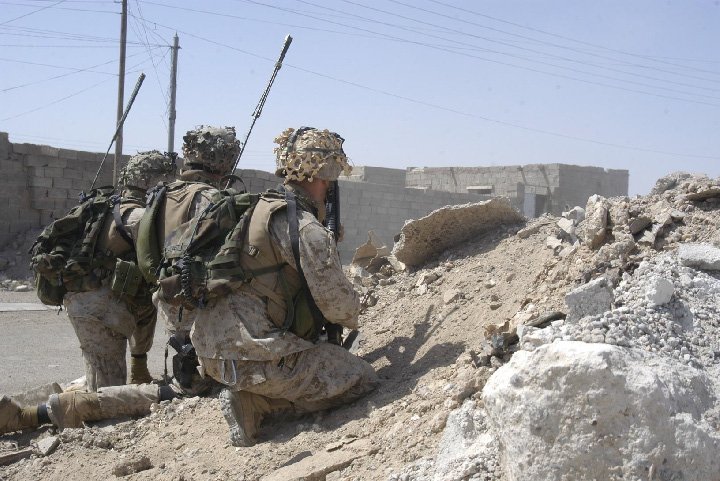 Three soldiers on rubble in Fallujah.