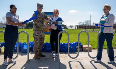 U.S. Air Force Col. Chris Robinson, 375th Air Mobility Wing commander, and Alicia Steele, Spark Adolescent Resources president, cut a ribbon during a ceremony on Scott Air Force Base, Illinois, April 3, 2023. On-base families have access to the blessing box, made to provide free nonperishable food items and household goods to combat food insecurity. Photo by Airman 1st Class Shelby Rapert, courtesy of the U.S. Air Force.
