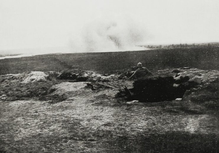 French soldier standing in a trench in the middle of a battlefield