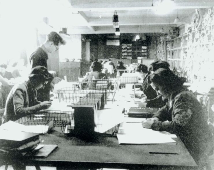 Men and women working at a long desk