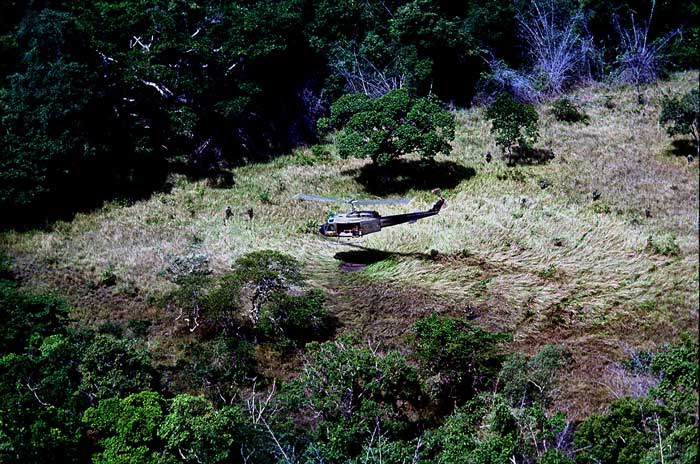 A UH-1B “Huey” lands with a squad of infantry. Photo by Marvin J. Wolf.
